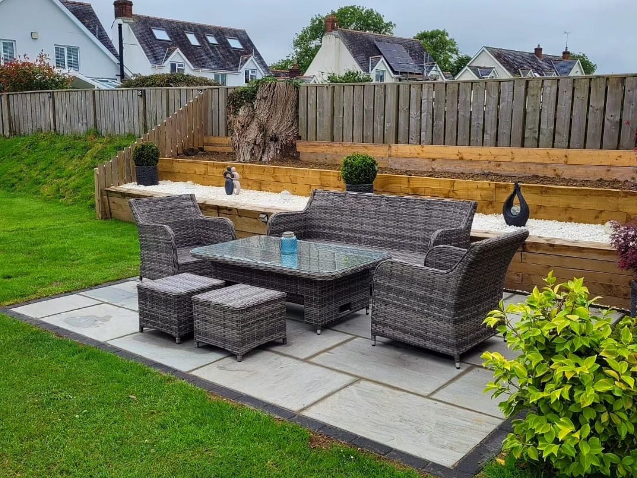 Sandstone patio with sleeper beds and lawn