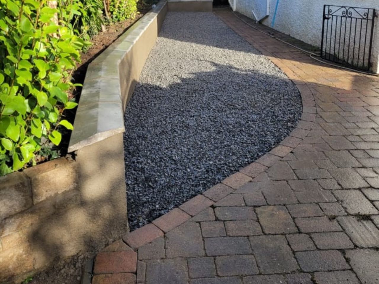 Block paving with a curved slate gravel bed