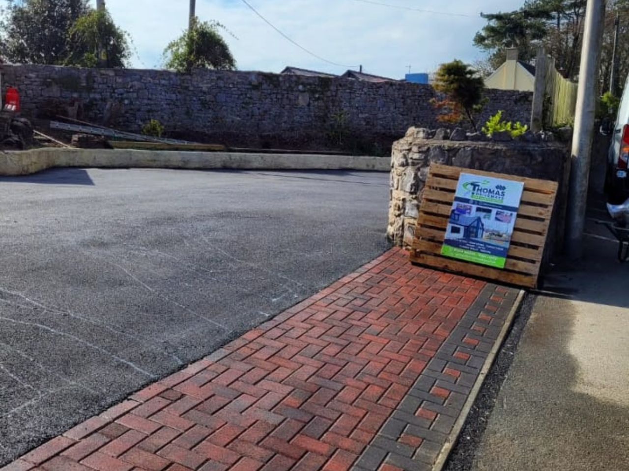 Tarmac parking area with red block paved apron
