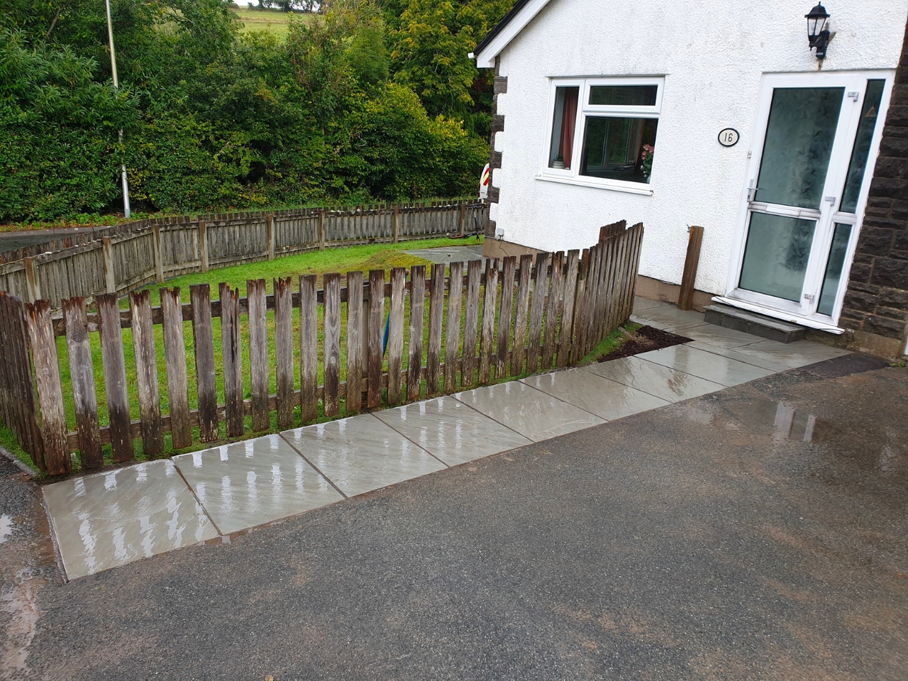 Sandstone path and dropped kerb at a white bungalow