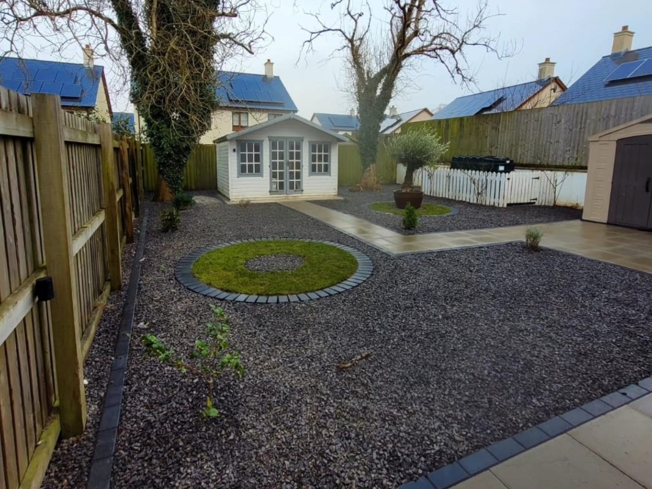Gravel garden with summerhouse and circular lawn feature