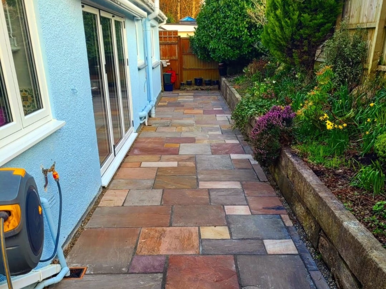 Thomas Driveways worker jet washing a finished patio